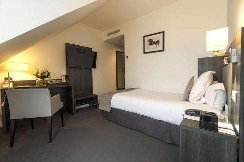 een hotelkamer met een groot bed en een bureau bij Best Western Plus Hotel Du Parc Chantilly in Chantilly