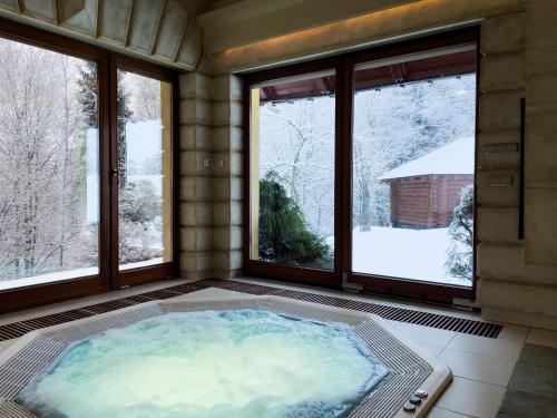 jacuzzi en una habitación con ventanas en Top Mountain Villa, en Wisła