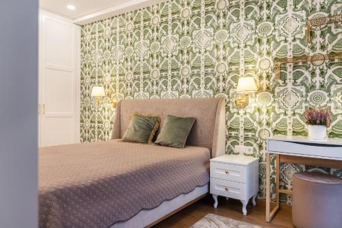 a bedroom with a bed with a green and white wallpaper at Lux Apartment With A Terrace In Vilnius Old Town in Vilnius