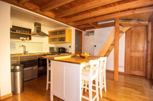 een keuken met een wit eiland en houten plafonds bij Chalet Brio in Samoëns