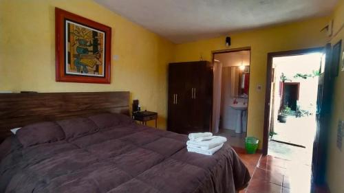 um quarto com uma cama grande e uma casa de banho em Hostel Ibirapita em La Paloma