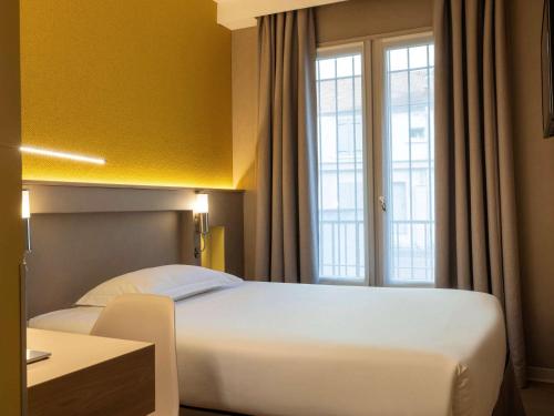 una camera d'albergo con letto e finestra di ibis Styles Bourg La Reine a Bourg-la-Reine