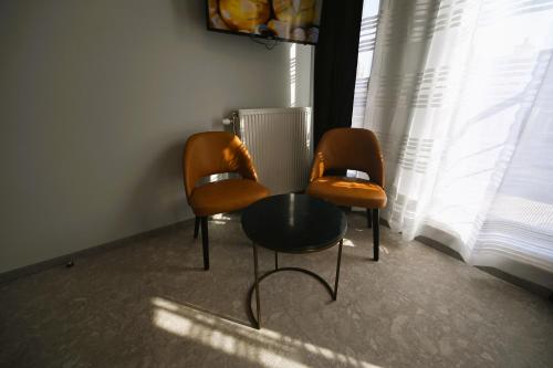 2 chaises et une table devant une fenêtre dans l'établissement Cesar Palace, à Ostende