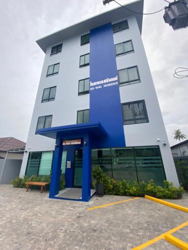 un grand bâtiment blanc avec un bleu dans l'établissement Nai Yang Residence, à Nai Yang Beach