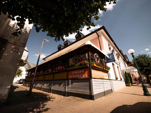 een gebouw op een straat met bloemen erop bij Hotel Club in Kežmarok