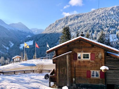 een blokhut in de sneeuw met bergen op de achtergrond bij Sonniges Chalet Arosa für 6 Pers alleinstehend mit traumhaftem Bergpanorama in Langwies