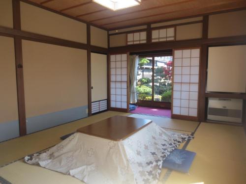 una stanza con tavolo al centro di una stanza di Shitanda a Takayama