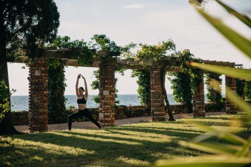 una mujer haciendo una pose de yoga bajo un arco en Vila Tartini, en Strunjan