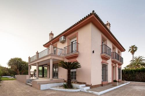 Cette grande maison rose dispose d'un balcon. dans l'établissement Villa Triana4, à Valencina de la Concepción