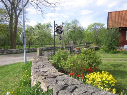 um jardim com flores e uma parede de pedra em Länsmansgården em Färjestaden