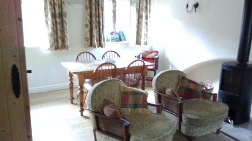 una sala da pranzo con tavolo, sedie e piano cottura di Millstone cottage a Oldham