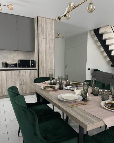 comedor con mesa y sillas verdes en MoonLight, en Slavske