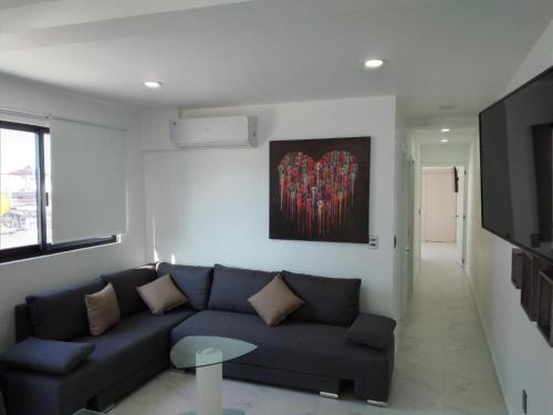 a living room with a couch and a flat screen tv at Venecia 262 in Puerto Vallarta