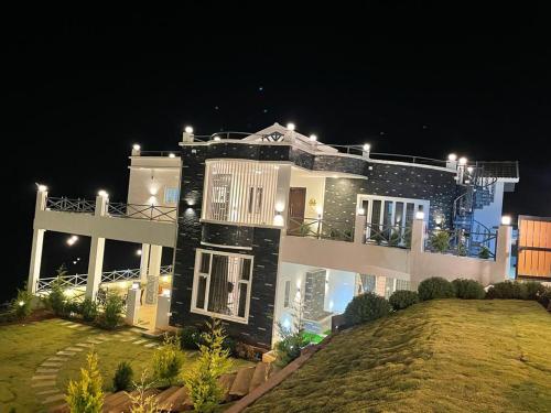 una casa grande con luces encima en Orchard Valley View Home Stay, en Ooty