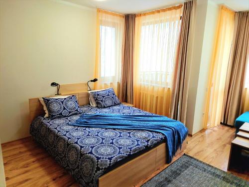 Schlafzimmer mit einem Bett mit blauer Decke in der Unterkunft Студио D-41 в Апарт-хотел Боровец Гардънс in Borowez