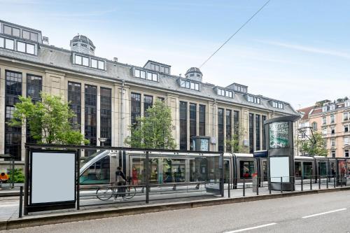 uma paragem de autocarro em frente a um grande edifício em Appart'City Confort Strasbourg Centre em Estrasburgo