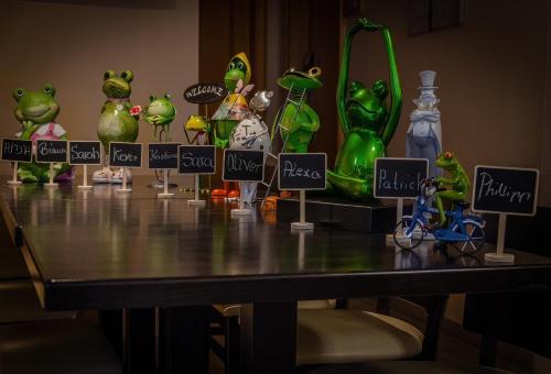 a table with a bunch of frog figurines on it at Hotel Aulmann in Trier