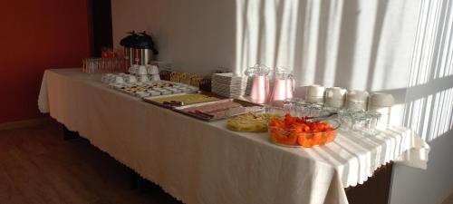 una larga mesa blanca con comida. en Hotel CESARE, en Uyuni