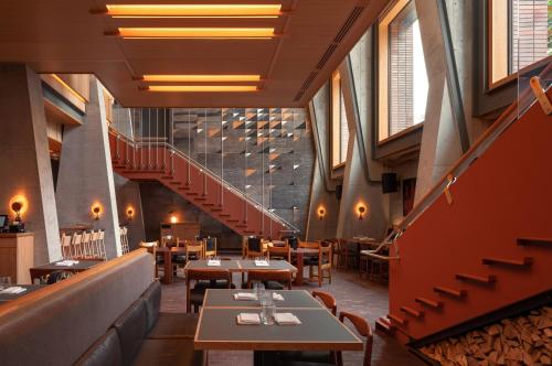 um restaurante com mesas, cadeiras e escadas em Ace Hotel Toronto em Toronto