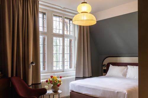 een slaapkamer met een bed en een groot raam bij Boutique Hotel Waldhaus beider Basel in Bazel