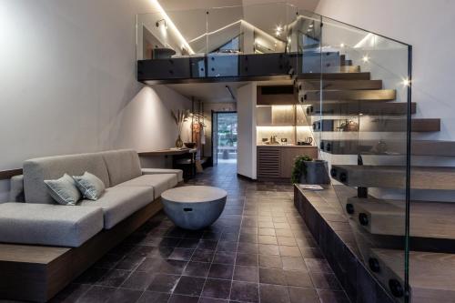 sala de estar con sofá y escalera en ACRO Upscale Residences, en Kórinthos