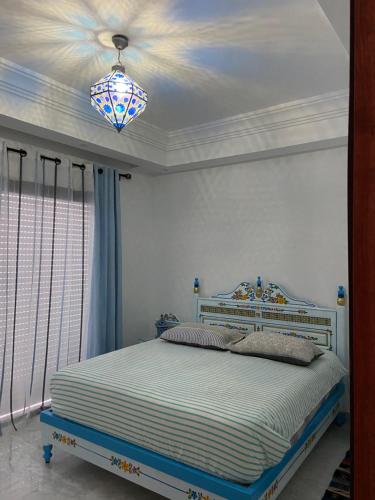 a bedroom with a bed and a chandelier at Marsa Central Splendid Appart 2 in La Marsa