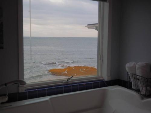 un bagno con finestra affacciata sull'oceano di Casa al Mare Beachfront Retreat King Bed Near Yale a East Haven