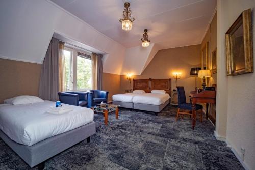 una camera d'albergo con 2 letti e una scrivania di Fletcher Hotel Apeldoorn ad Apeldoorn