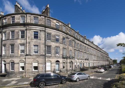 um grande edifício com carros estacionados em frente em 1 Bellevue Terrace em Edinburgo