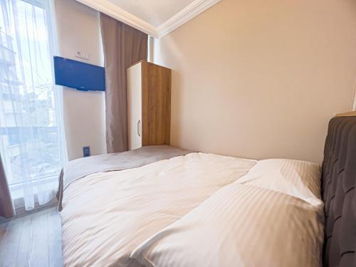 a white bed in a room with a window at Helen Inn in Izmir