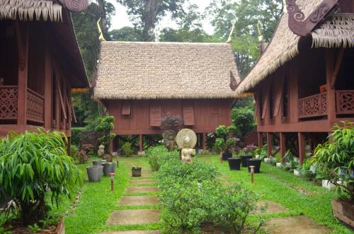 a house with a garden in front of it at Lanna Ban Hotel in Puerto Viejo