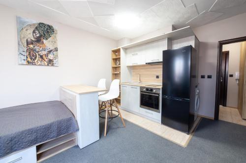 een kleine kamer met een bed en een zwarte koelkast bij Luxury Studio Apartment - Varna Residens in Varna