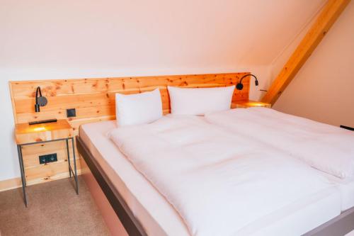 two twin beds in a room with a wooden headboard at Hotel Andres in Bamberg