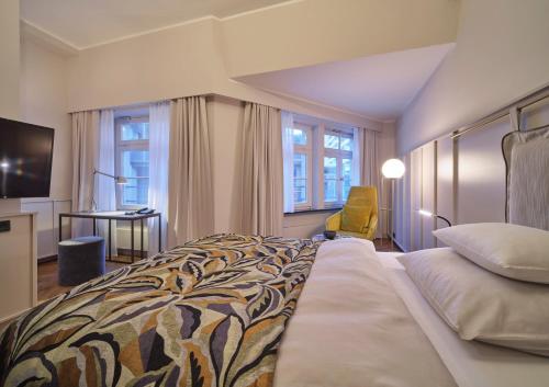 a hotel room with a large bed and a desk at Classik Hotel Alexander Plaza in Berlin