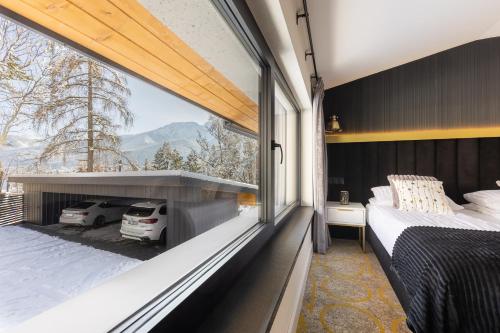 una camera da letto con balcone, letto e finestra di Tatry Residence SPA a Kościelisko