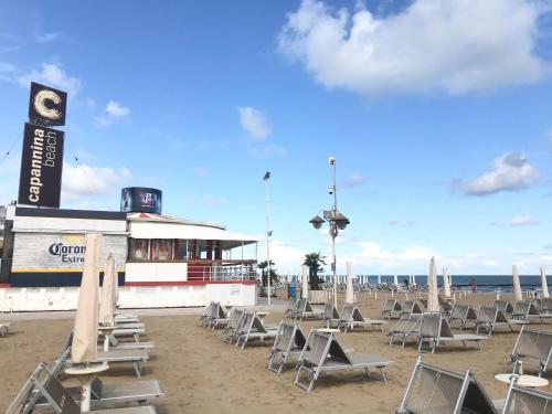 a beach with chairs and a building on the beach at Anima Jesolo - Ca' delle Rose in Lido di Jesolo