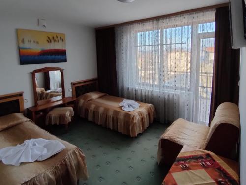 ein Hotelzimmer mit 3 Betten und einem Spiegel in der Unterkunft Guest Rooms Grachenovi in Bansko