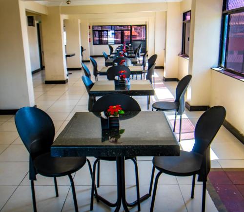 une rangée de tables et de chaises dans un restaurant dans l'établissement Hotel Pirâmide Rodoviária, à Salvador