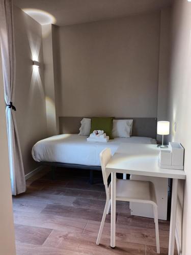 a bed in a room with a table and a bed at La Casona del Eboni in Alcalá de Henares