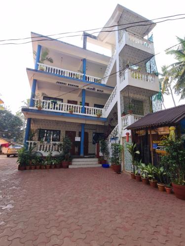 Un grand bâtiment blanc avec balcon se trouve dans une rue. dans l'établissement Palolem Sunrise Apartment, à Palolem