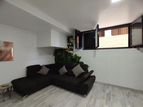 uma sala de estar com um sofá preto e algumas janelas em Sweet Apt Charco by flamingo house em Arrecife