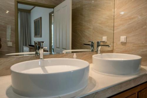 a bathroom with a white sink and a mirror at Grand Large - Premium suite in Papeete