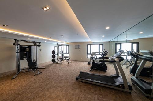 einen Fitnessraum mit Laufbändern und Kardiogeräten in einem Zimmer in der Unterkunft Cebu Family Suites powered by Cocotel in Cebu City