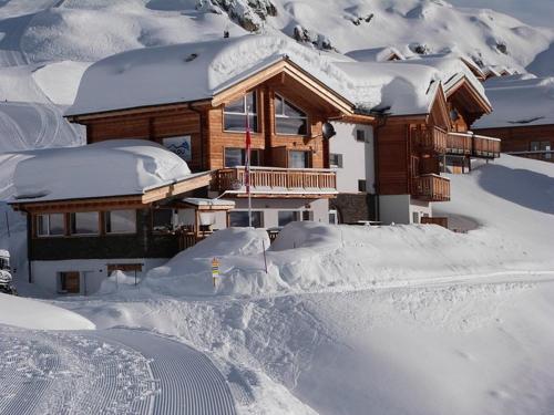 dom pokryty śniegiem z przodu w obiekcie Hotel Harmony Tigilou Belalp w mieście Belalp