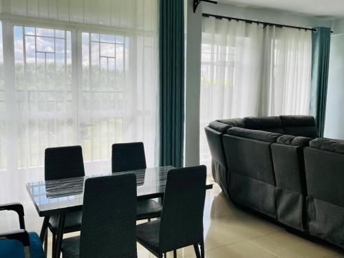 ein Wohnzimmer mit einem Tisch und einem Sofa in der Unterkunft Zoe Homes 1br and 2br Apartment Greypoint 406 in Kericho