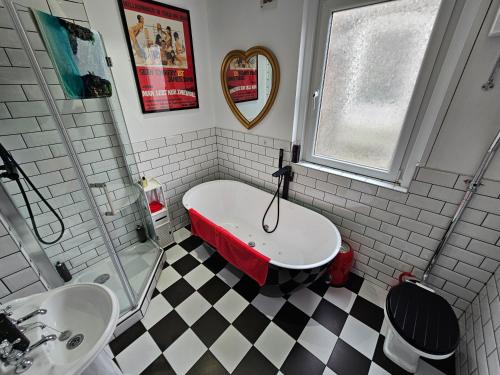 bagno con vasca e lavandino di Southsea Royale James Bond 3 bed Cool Penthouse, seafront parking a Portsmouth