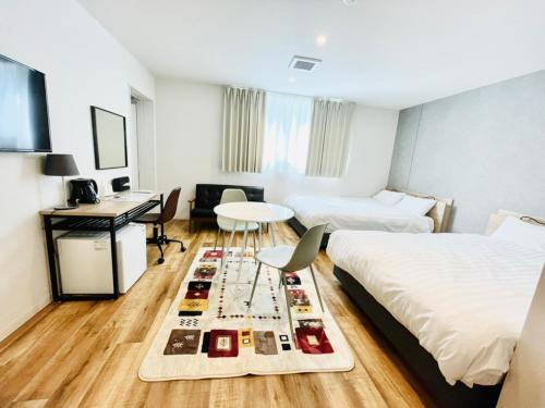 een kamer met 2 bedden, een tafel en een bureau bij Megu fuji 2021 - Vacation STAY 74531v in Fujiyoshida