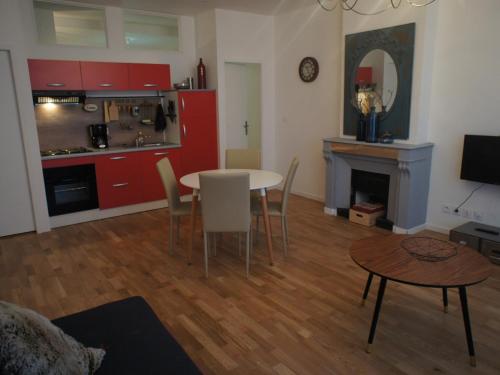 een woonkamer met een tafel en stoelen en een keuken bij AppartsHotels'De Ville in Bourg-lès-Valence