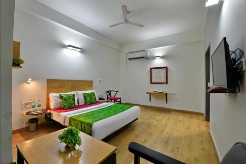 a hotel room with a bed and a table at Divine Inn Couple Friendly Hotel near Sector 51 Metro Station in Noida