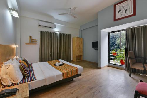 a hotel room with a bed and a window at Divine Inn Couple Friendly Hotel near Sector 51 Metro Station in Noida